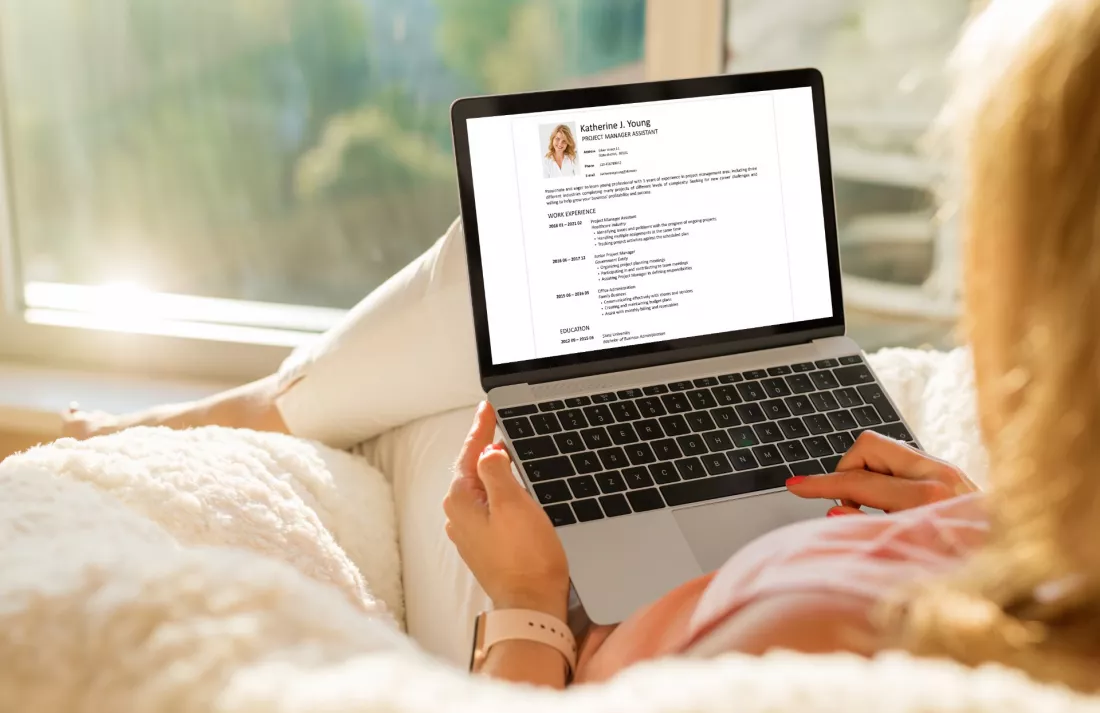Young woman creating her first CV on a laptop at home